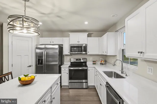 a kitchen with stainless steel appliances a stove a sink a refrigerator and cabinets