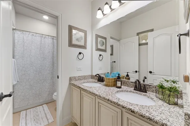 a bathroom with a granite countertop sink a mirror and a shower