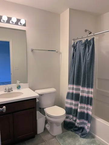 a bathroom with a sink a toilet a mirror and shower
