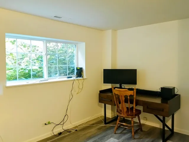 a view of a workspace with furniture and a window