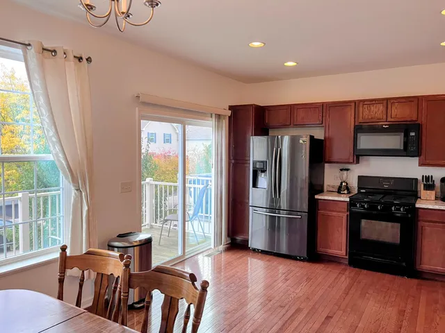 a kitchen with stainless steel appliances granite countertop a refrigerator microwave and wooden floor