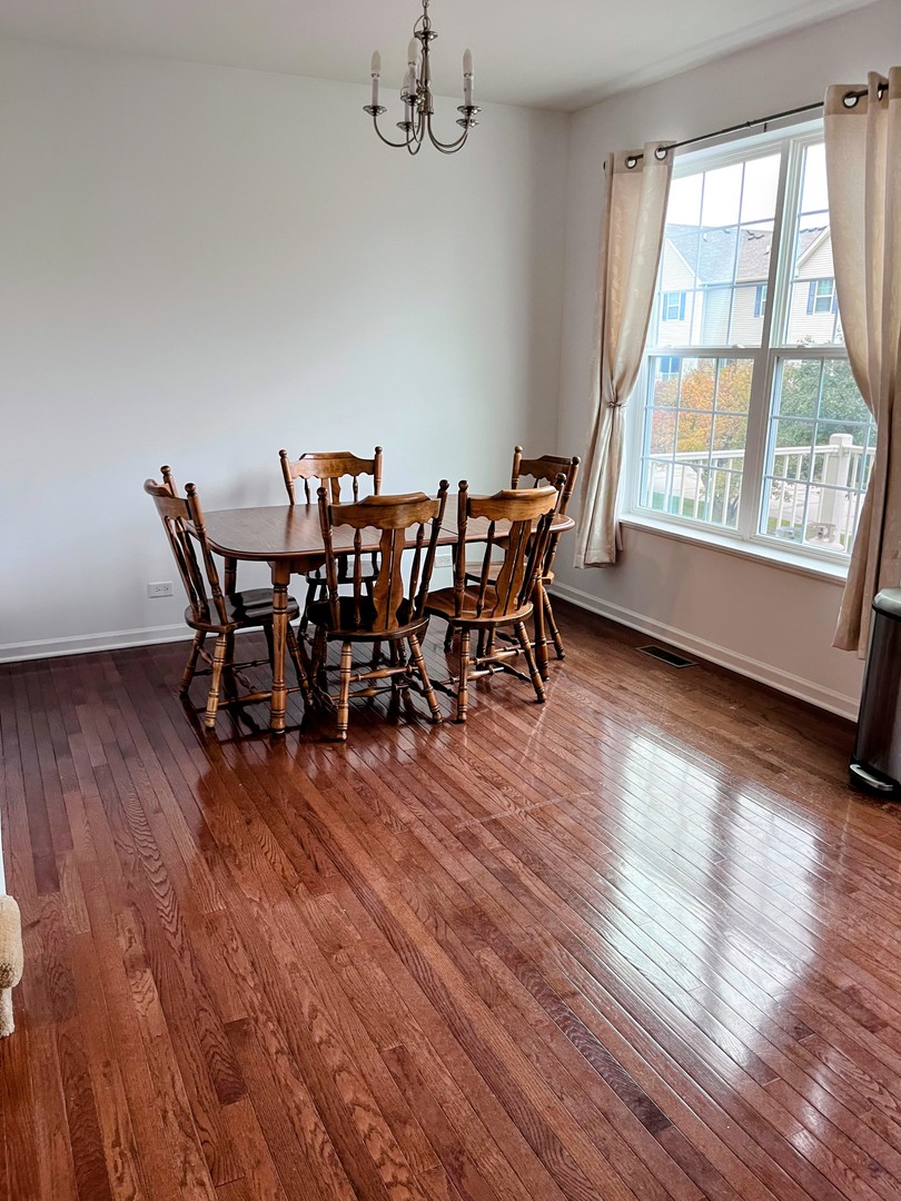 434 Town Center Boulevard Gilberts, IL 60136 - Photo 8 of 18 a view of a dining room with furniture window and wooden floor
