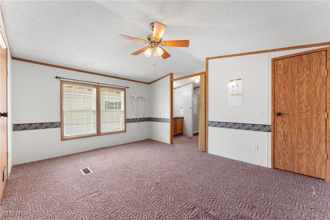 4455 Cleveland Road, Unit 6 Wooster, OH 44691 - Photo 14 of 40 Spare room with carpet, a textured ceiling, ceiling fan, and crown molding