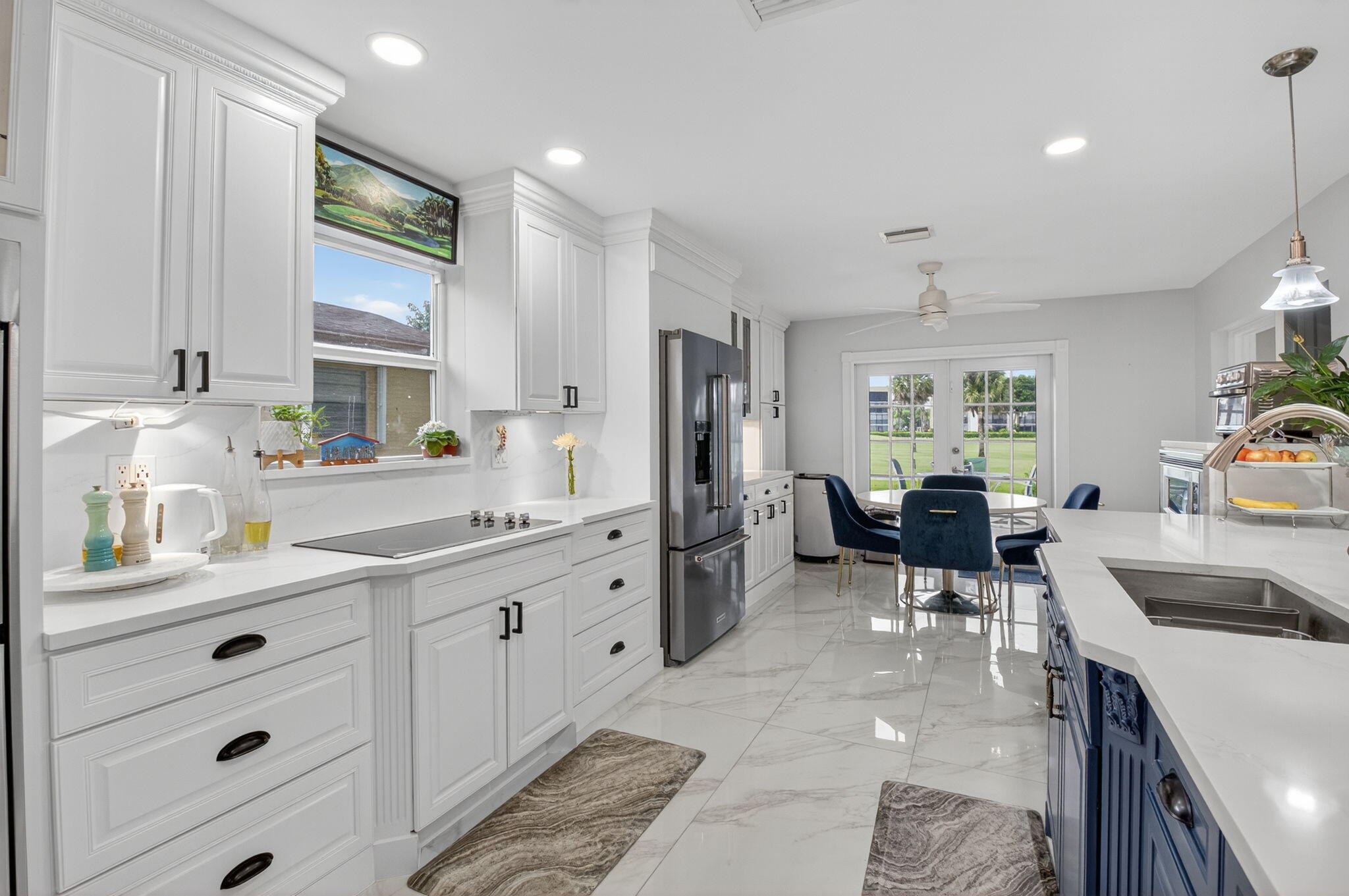 23265 Southwest 61st Avenue Boca Raton, FL 33428 - Photo 12 of 44 a kitchen that has a lot of cabinets a sink and appliances in it