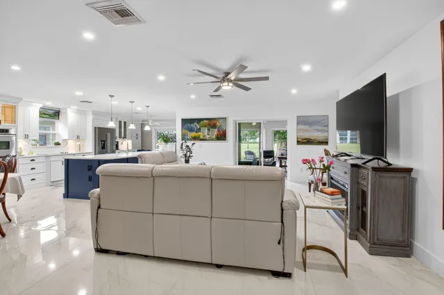 a living room with furniture a flat screen tv and a table