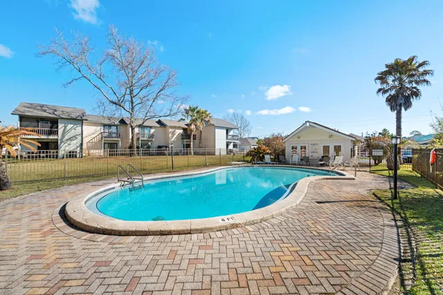 a view of a swimming pool with a patio and a yard
