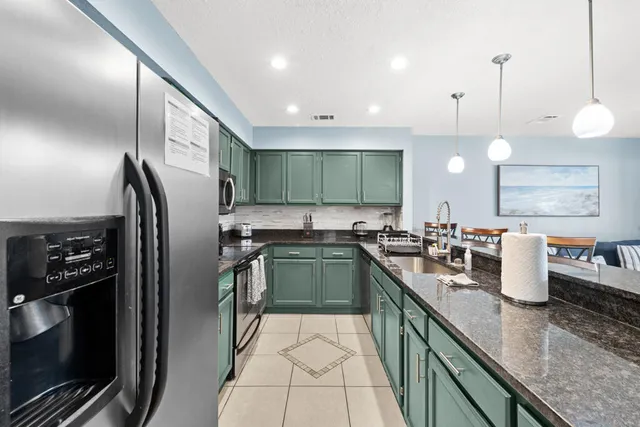 a kitchen with stainless steel appliances granite countertop a sink stove and cabinets