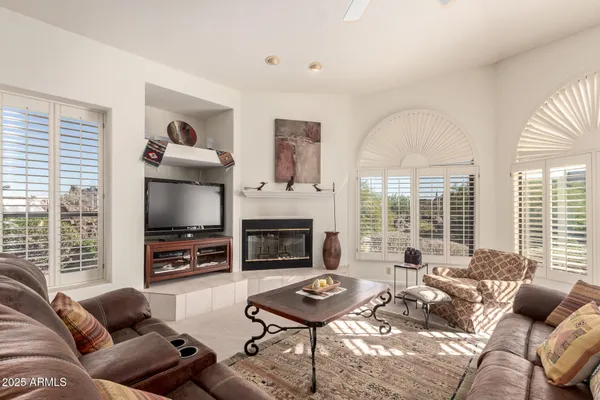 a living room with furniture a flat screen tv and a fireplace