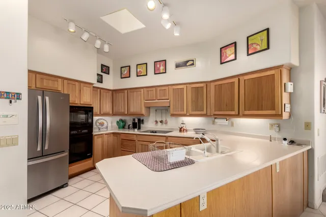 a kitchen with stainless steel appliances granite countertop a sink refrigerator and cabinets