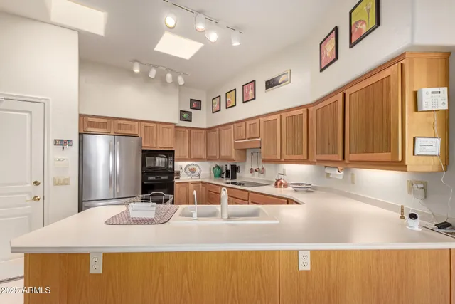 a kitchen with stainless steel appliances granite countertop a sink refrigerator and cabinets