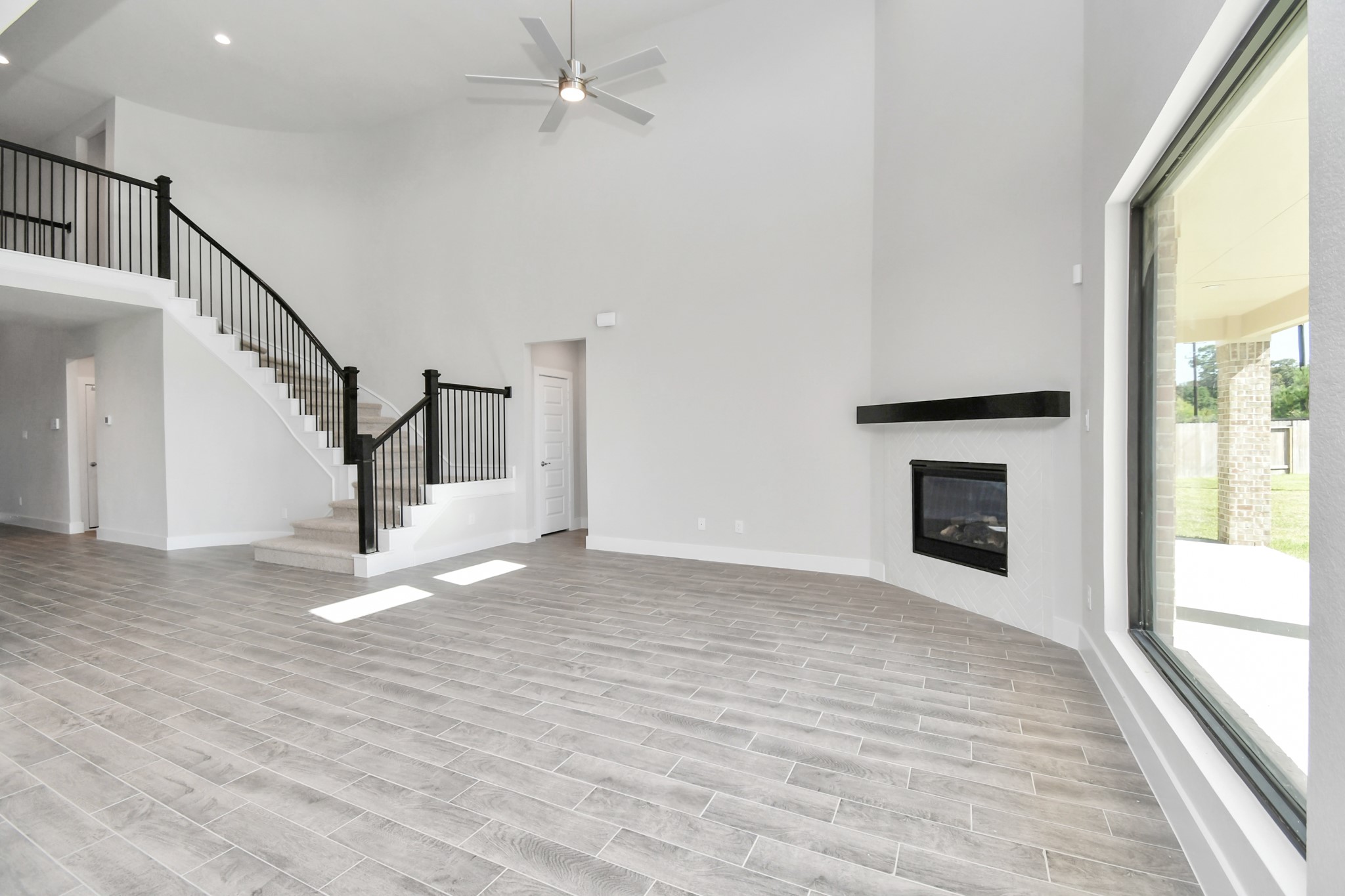 3103 Native Spg Drive Spring, TX 77373 - Photo 16 of 36 Relax and unwind in this inviting family room, illuminated by abundant natural light streaming in through tall windows, complemented by high ceilings and stunning flooring. Stay comfortable year-round with the gentle breeze from the ceiling fan, creating the perfect atmosphere for family gatherings. Sample photo of completed home with similar floor plan. Actual colors and selections may vary.