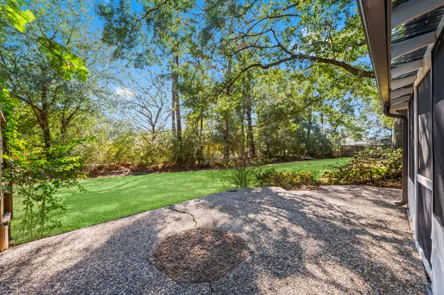 a view of a house with a large tree and a yard