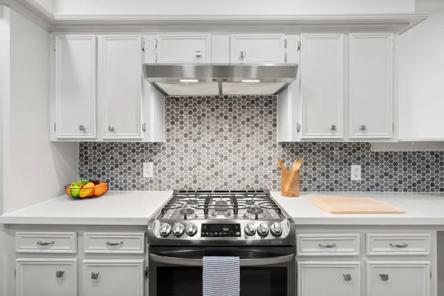 a kitchen with a sink a counter top space stainless steel appliances and cabinets