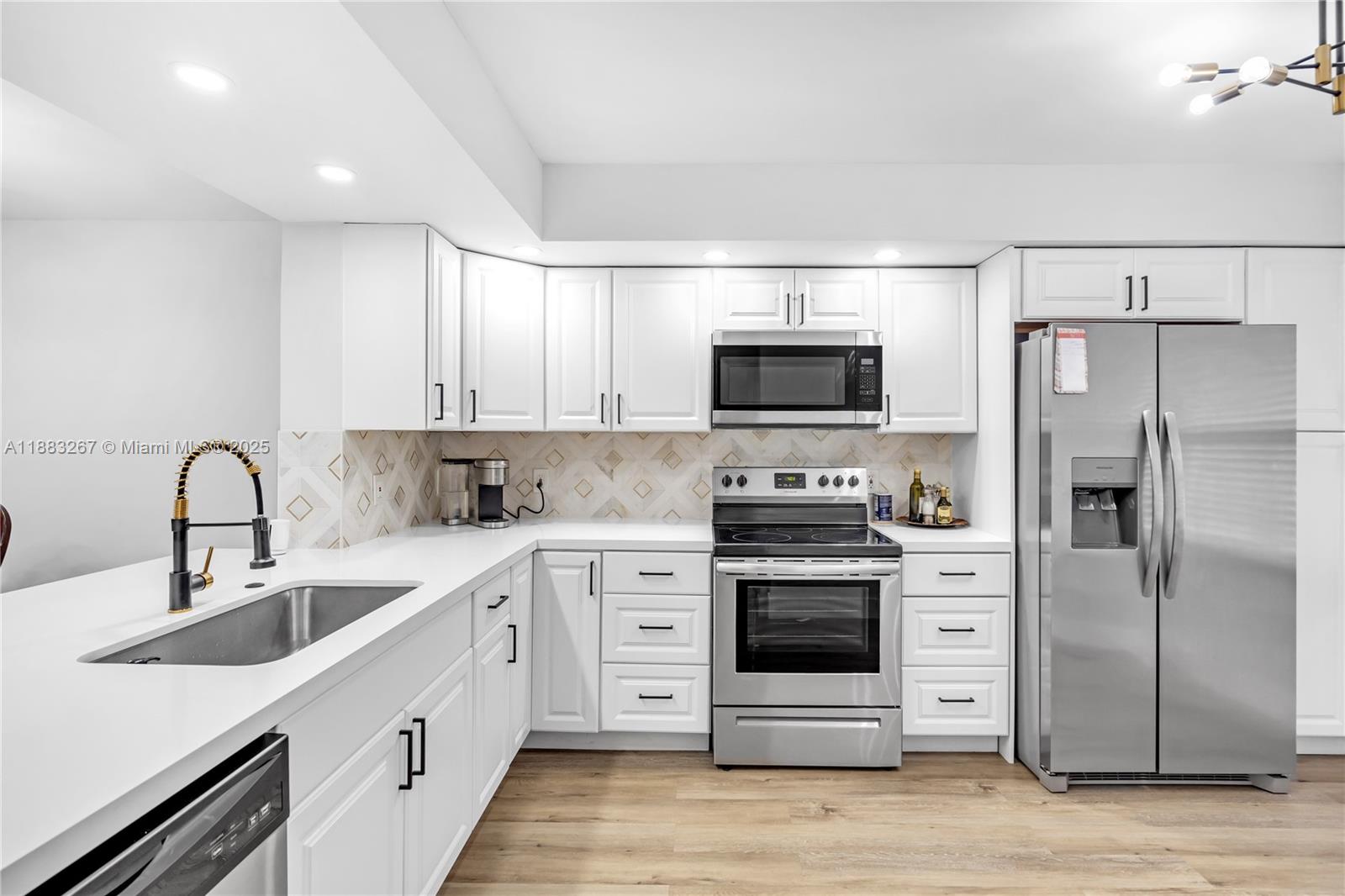 a kitchen with stainless steel appliances a stove sink and refrigerator