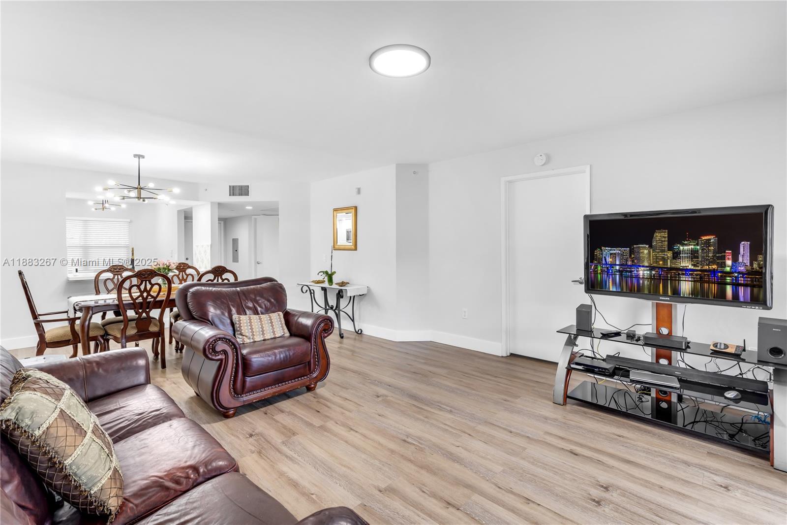 701 Southwest 142nd Avenue, Unit 108S Pembroke Pines, FL 33027 - Photo 11 of 25 a living room with furniture kitchen view and a wooden floor