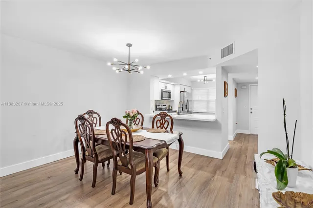 a view of a a dining room with furniture wooden floor and chandelier