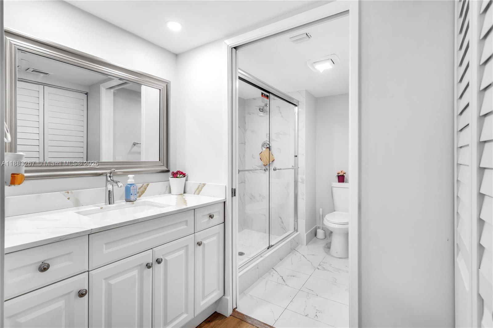 701 Southwest 142nd Avenue, Unit 108S Pembroke Pines, FL 33027 - Photo 17 of 25 a spacious bathroom with a granite countertop sink mirror and toilet