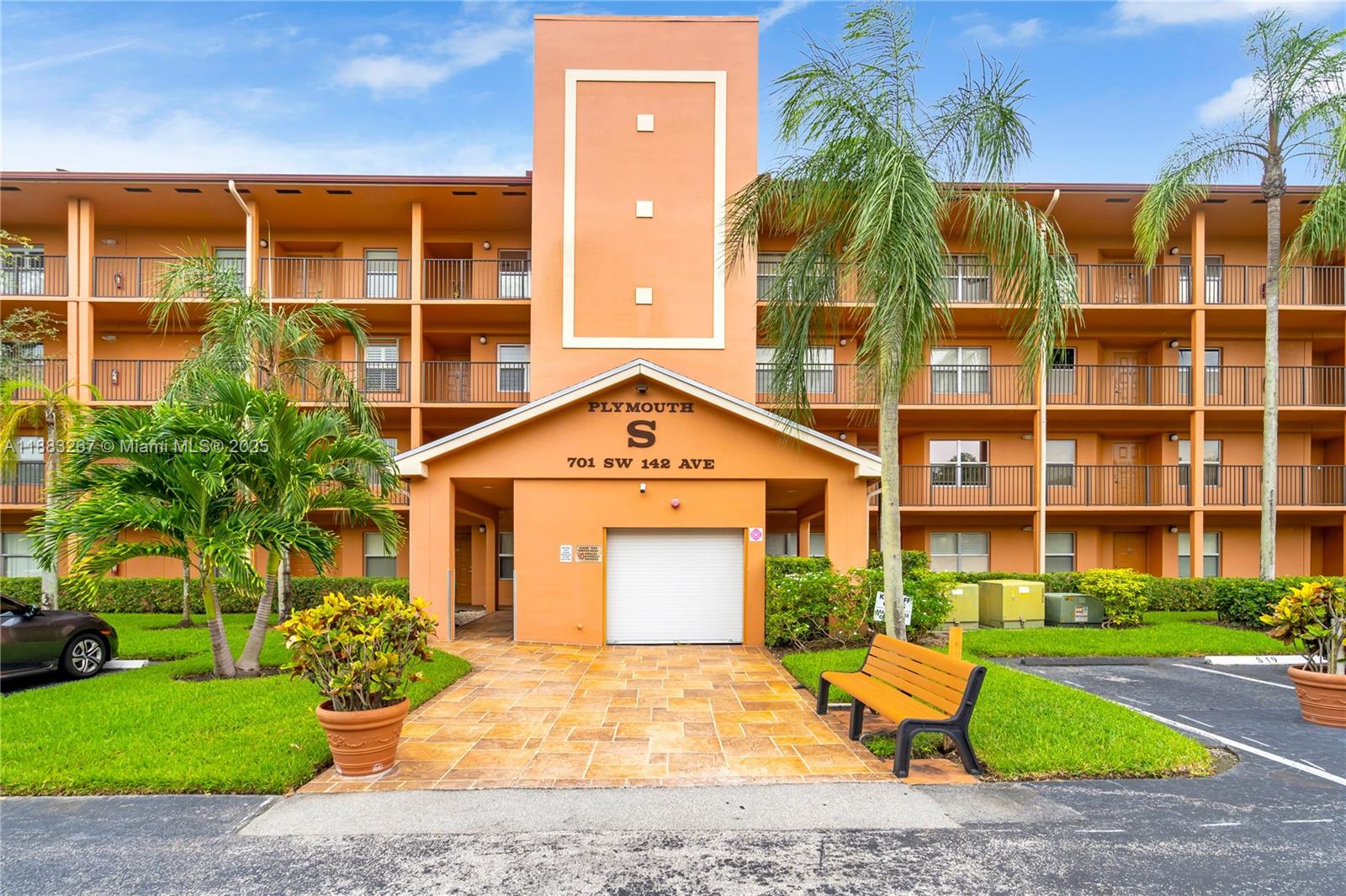 701 Southwest 142nd Avenue, Unit 108S Pembroke Pines, FL 33027 - Photo 21 of 25 a front view of a residential apartment building with a yard and potted plants
