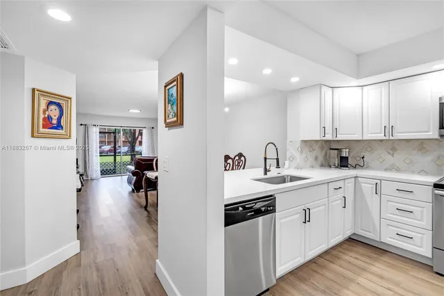 a kitchen with a sink cabinets and wooden floor