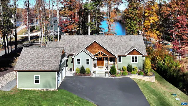 a view of a house with a yard and large trees