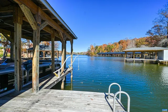 a dining room with wooden floor a chandelier a wooden table and chairs