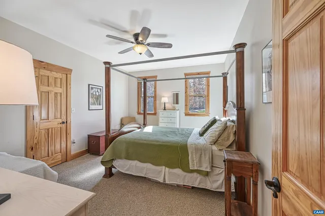 a front view of a house with a garden and lake view