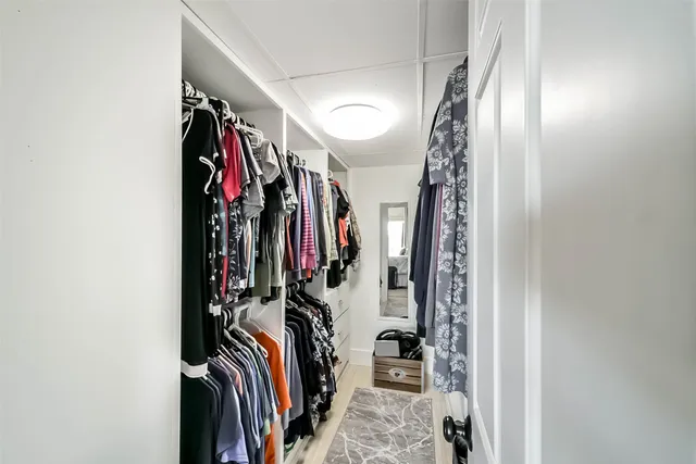 a view of walk in closet with clothes