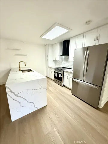 a kitchen with stainless steel appliances a refrigerator sink and stove
