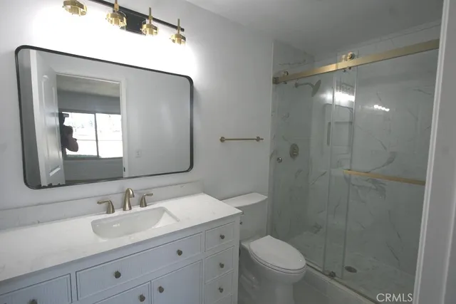 a bathroom with a toilet a sink and mirror