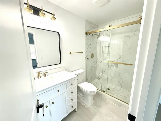 a bathroom with a double vanity sink toilet mirror and shower