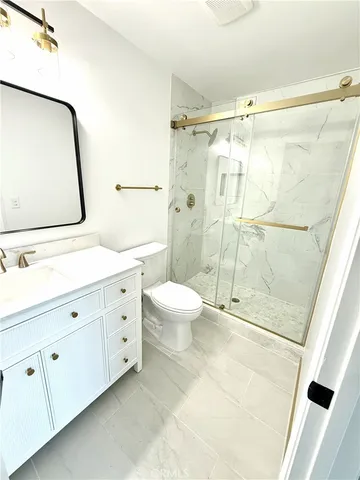 a spacious bathroom with a double vanity sink toilet and shower