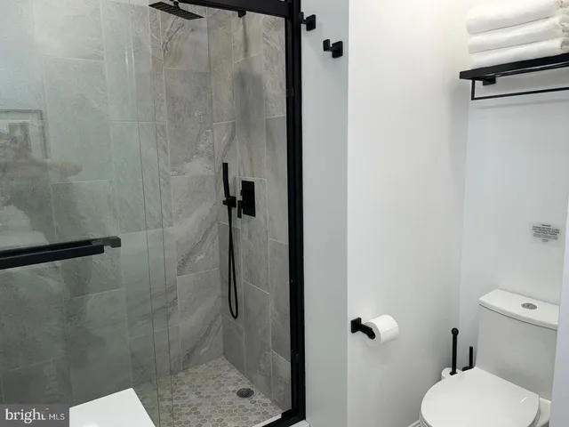 a white toilet sitting next to a shower
