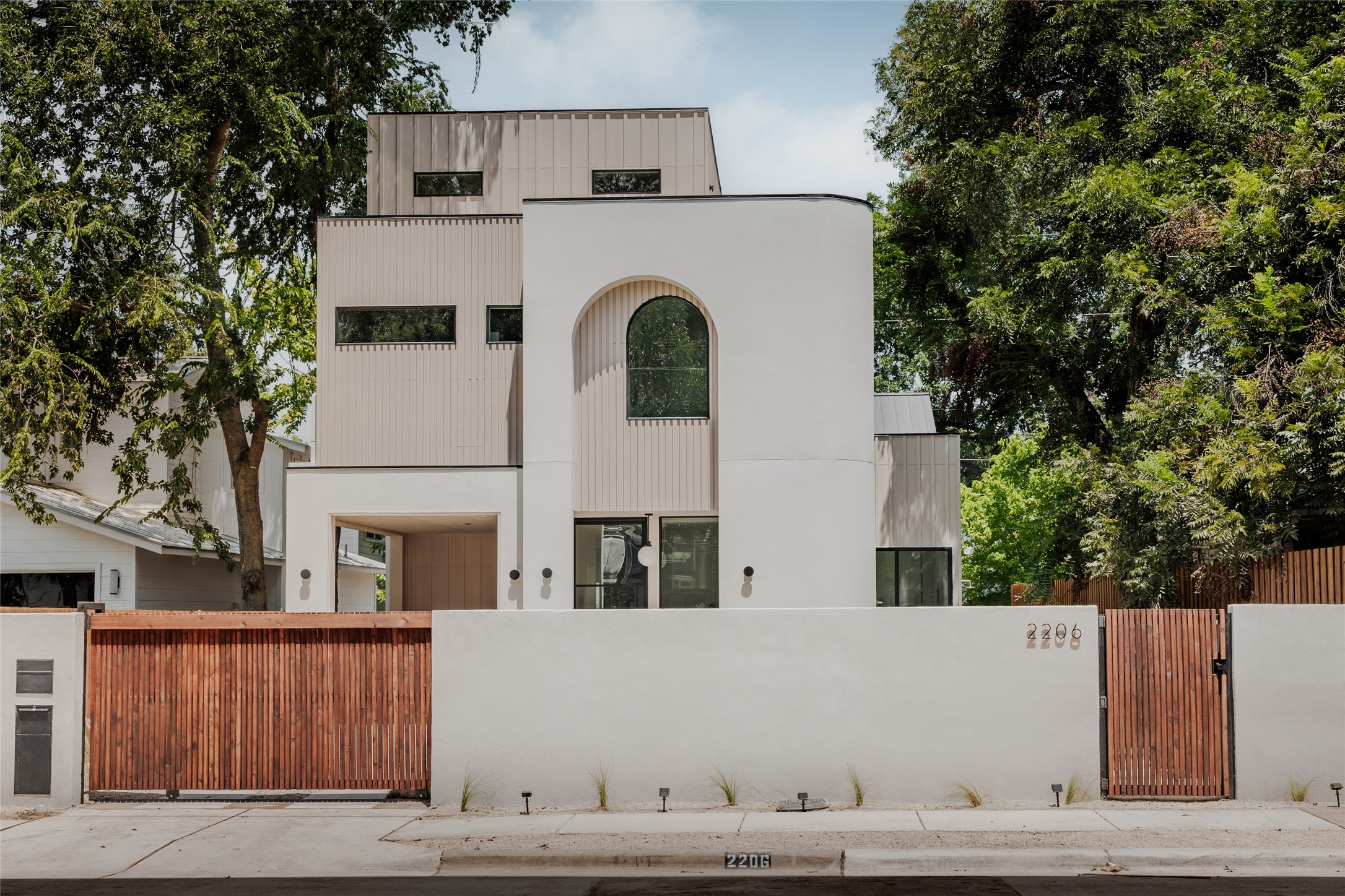 View of front facade featuring a gate, a fenced front yard, and a metal roof