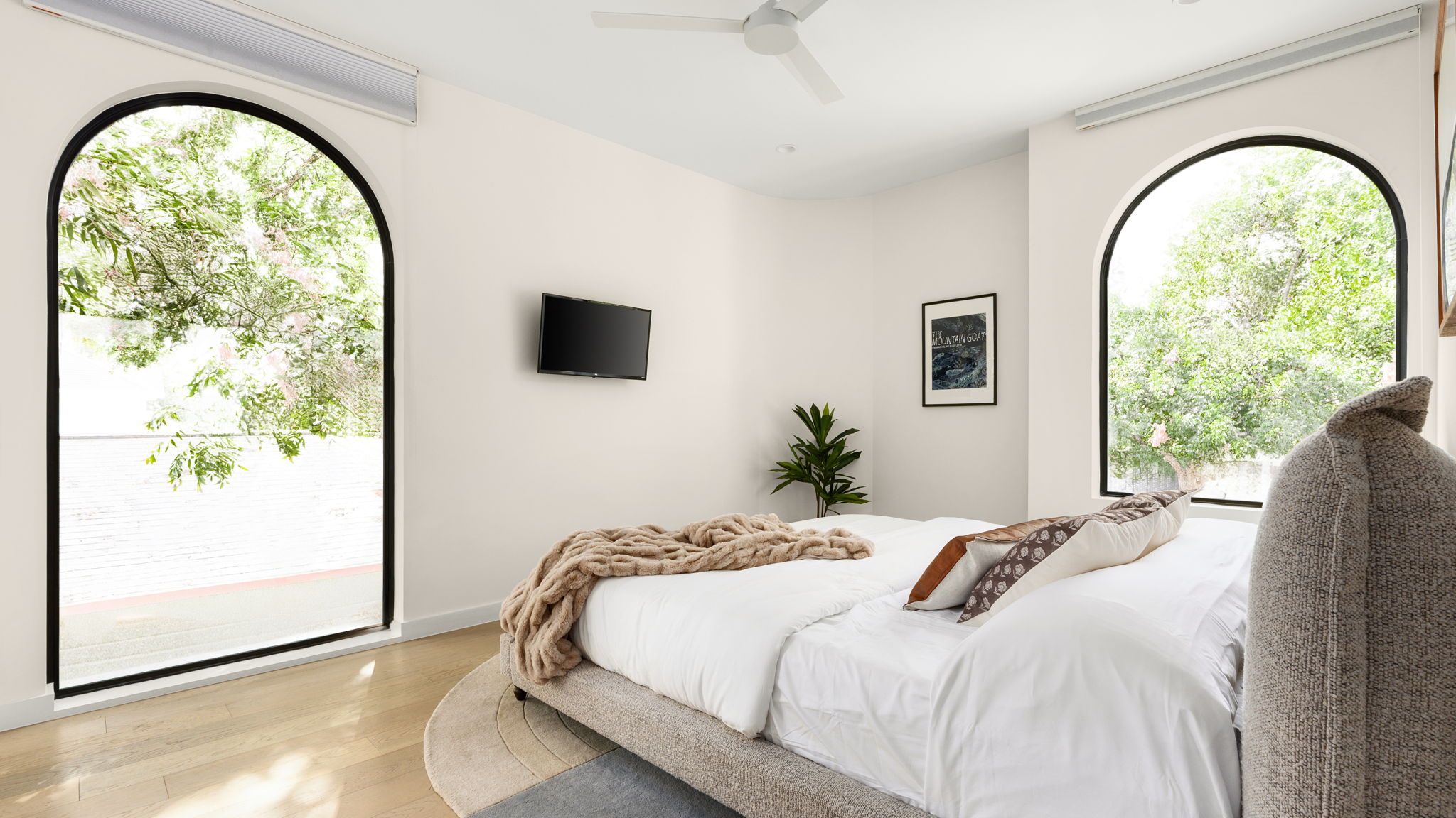 Undisclosed Address Austin, TX 78702 - Photo 19 of 38 Bedroom featuring light wood finished floors, multiple windows, and a ceiling fan