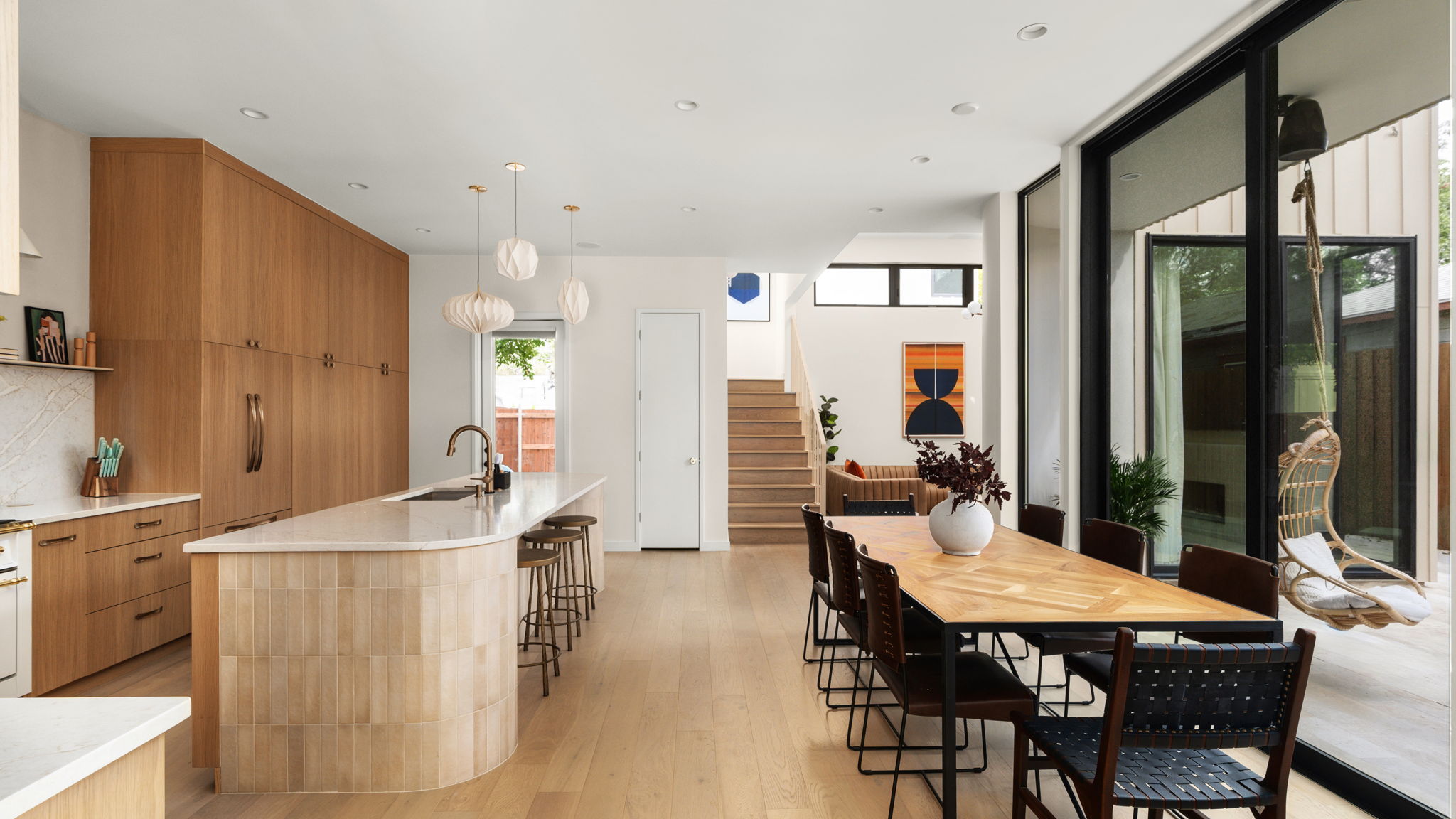 Undisclosed Address Austin, TX 78702 - Photo 4 of 38 Kitchen featuring modern cabinets, light wood finished floors, hanging light fixtures, a large island, and wood finish cabinetry