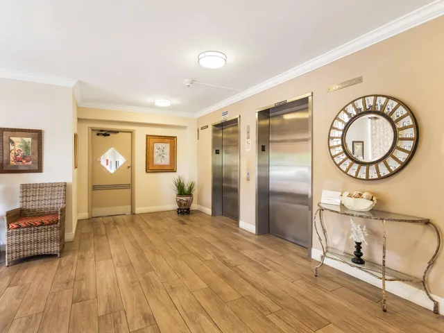 a view of a room with wooden floor mirror and windows