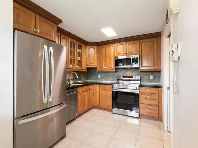 a kitchen with stainless steel appliances granite countertop a refrigerator stove and sink