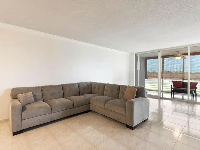 a living room with furniture and floor to ceiling window