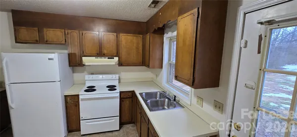 a kitchen with stainless steel appliances granite countertop a refrigerator a stove a sink and a microwave