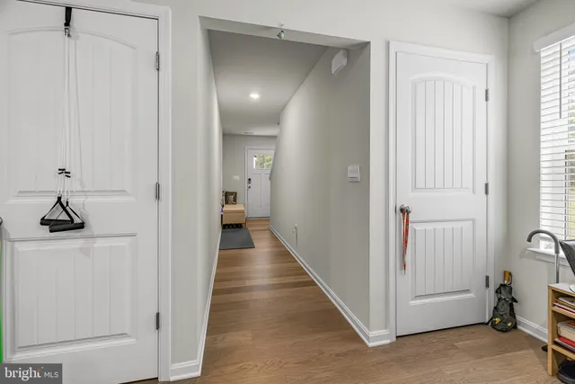 a view of a hallway with a closet and wooden floor