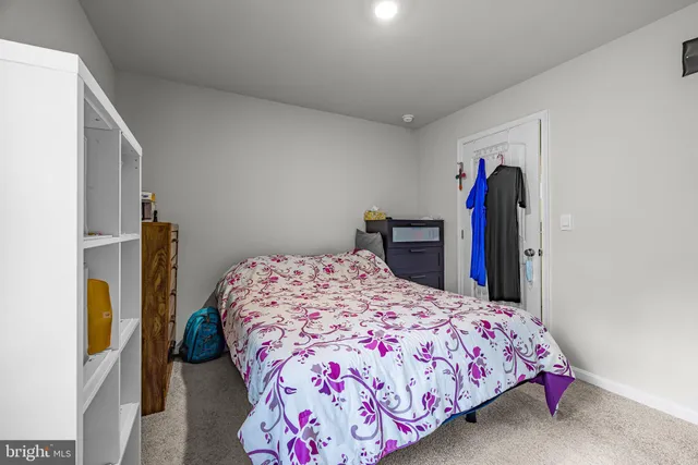 a bedroom with a bed and a flat tv screen on dresser