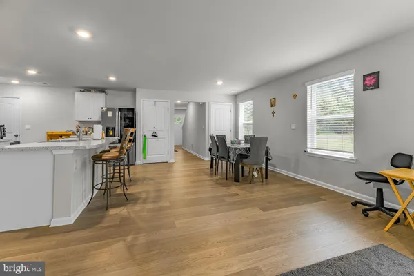 a room with stainless steel appliances dining table wooden floor and a window