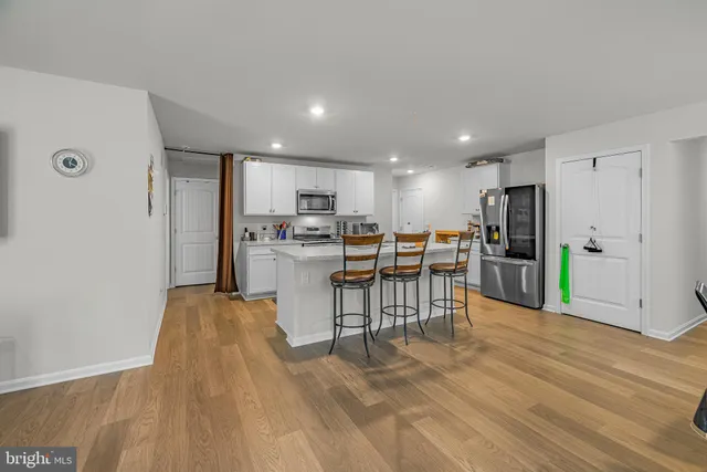 a view of kitchen with kitchen island and stainless steel appliances