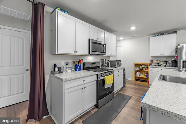 a kitchen with granite countertop a stove top oven and sink