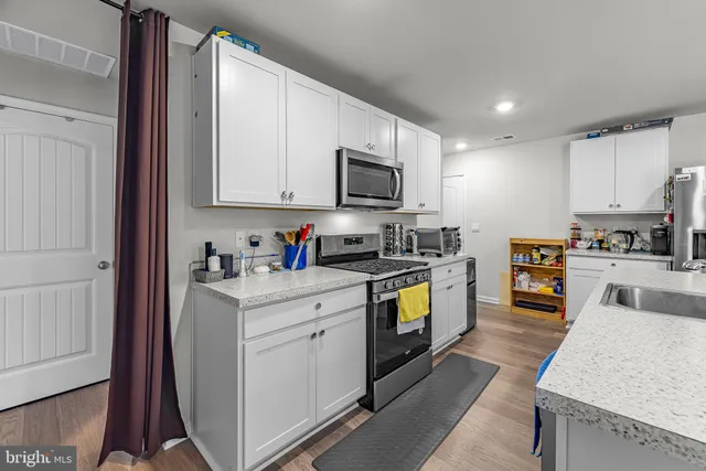 a kitchen with granite countertop a stove top oven and sink