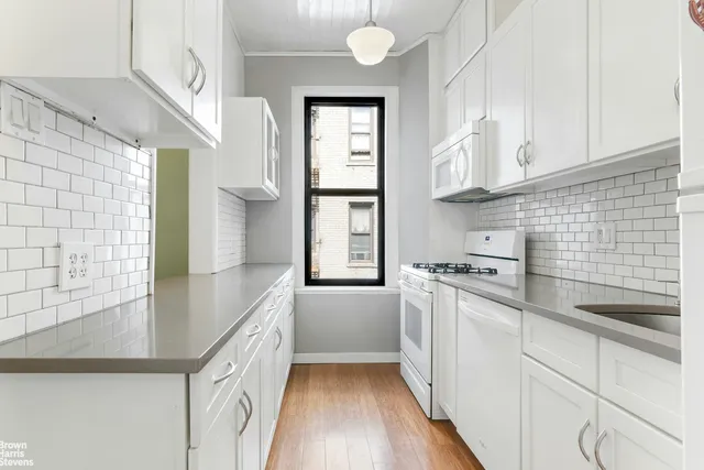 a dining hall with couches a dining table and chairs with wooden floor