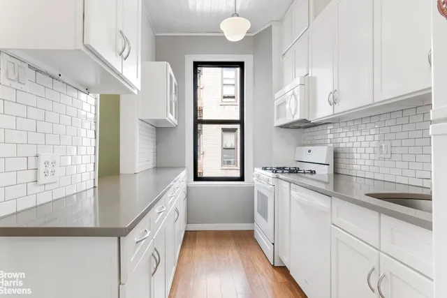 a dining hall with couches a dining table and chairs with wooden floor