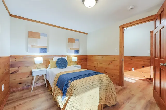 a bedroom with a bed and painting on the wall