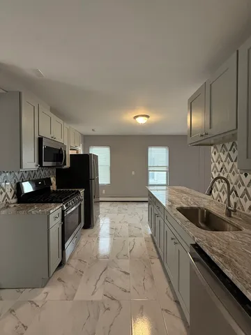 a kitchen with stainless steel appliances granite countertop a sink and a stove