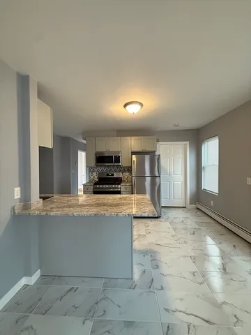 a large kitchen with a stove a sink a microwave and cabinets